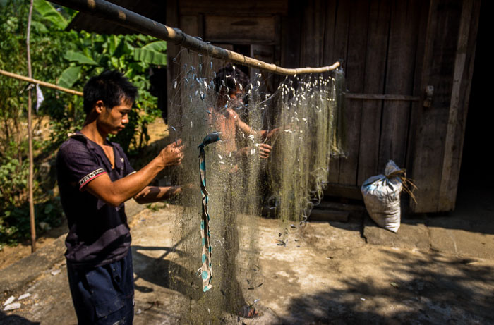 Fishermen fixing their nets on route Dong Van, Vietnam